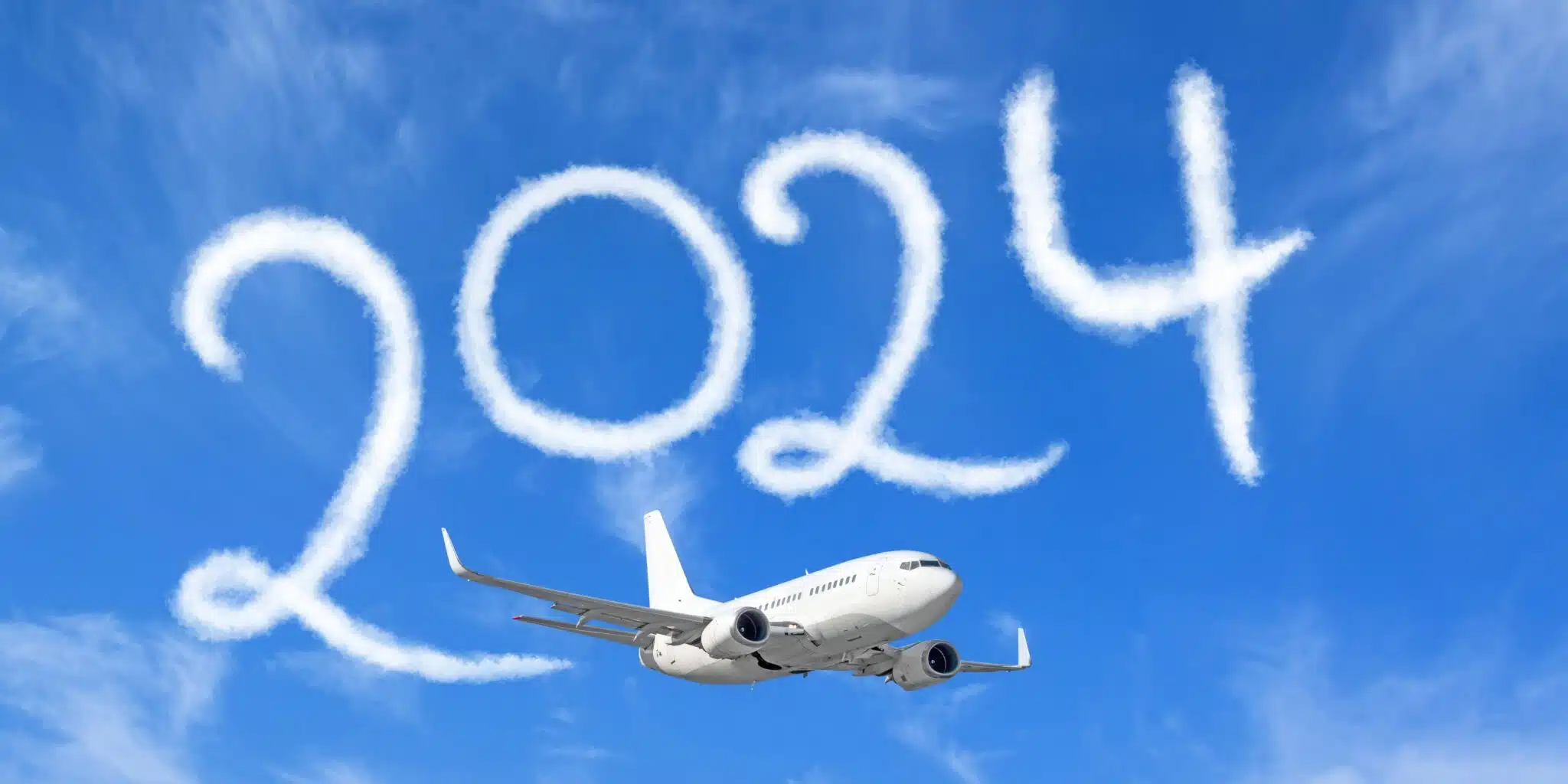 white plane flying in the sky with clouds shaped like "2024"